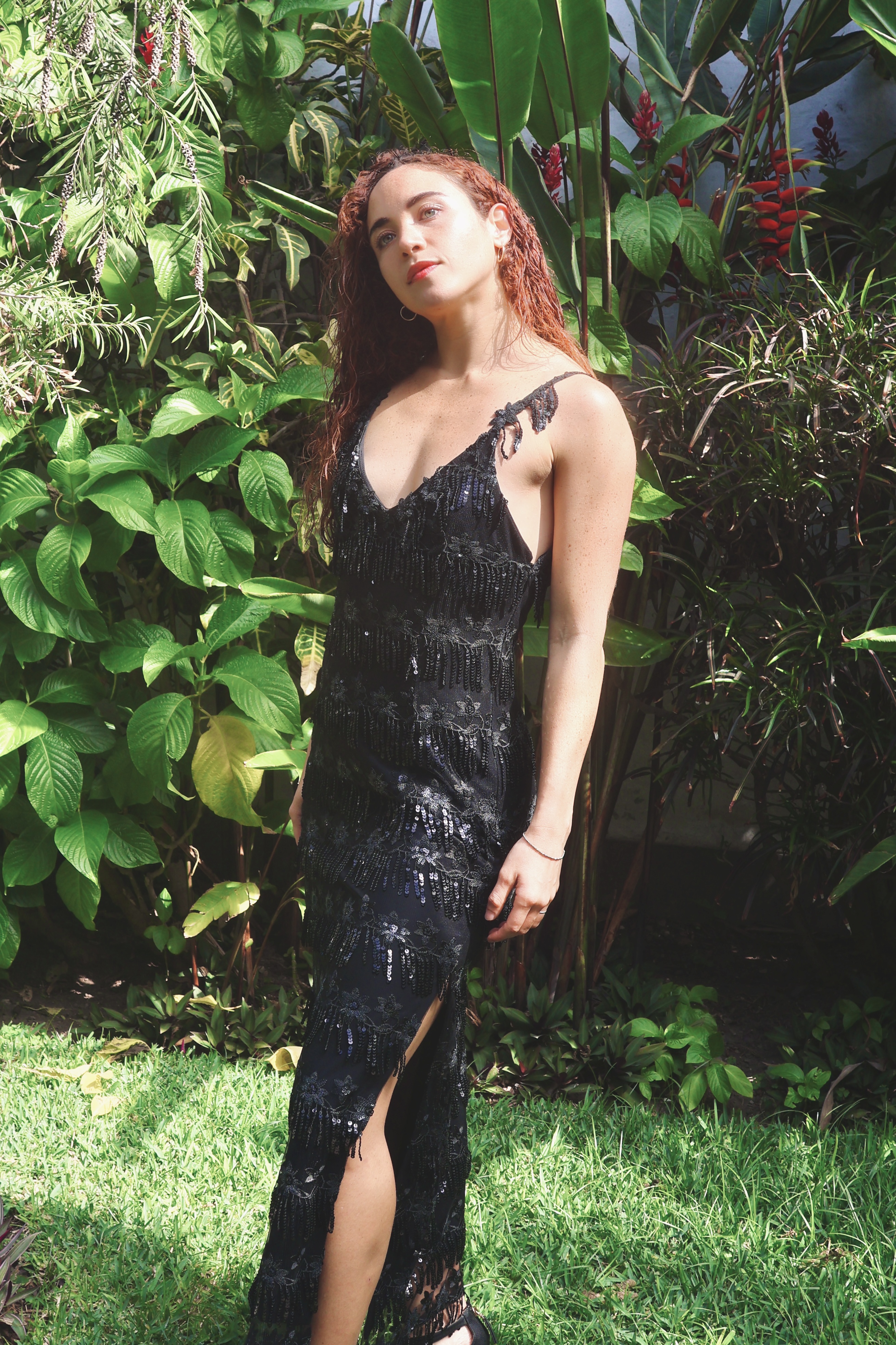 Vestido negro bordado con flores de lentejuelas de donde nacen delicados flecos que acompañan el movimiento con un brillo ondulante.
El escote suave enmarca el pecho con naturalidad, mientras la espalda escotada aporta una sensualidad sobria y segura.
Una pieza que vibra en profundidad, con ritmo propio y belleza contenida.

· Bordado negro con lentejuelas + flecos 
· Se adapta de S a M
· Pieza única – venta o alquiler
