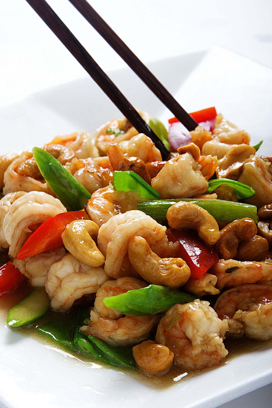 Langostinos salteados con verduras adornados de almendras chinas.