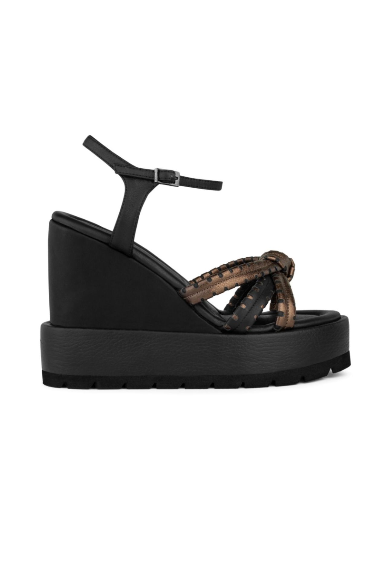 Las Aisha son las sandalias negras que necesitas para las salidas de noche de verano, junto con un toque de brillo en las tiras cruzadas hechas con una tecnica artesanal de picado en cuero bronce. 

La cuña sumada a la plataforma te darán la altura que necesitas sin perder la comodidad.


			                           DETALLES
			
		
			
			Taco
			
			
			
			                11 cm
			
		
			
			Color
			
			
			DARK BRONZE
		
			
			Material
			
			
			
			
			              CUERO
			
			
		